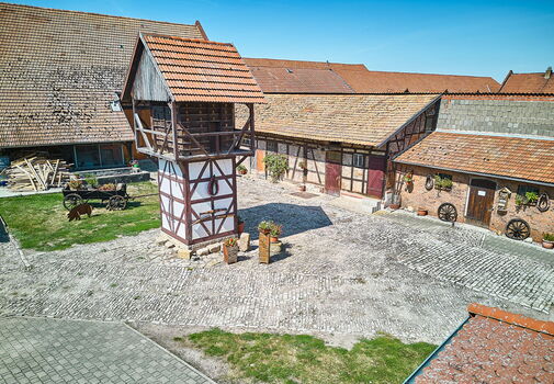 Blick auf den Edelhof in Mühlberg mit markantem Fachwerkturm in der Hofmitte