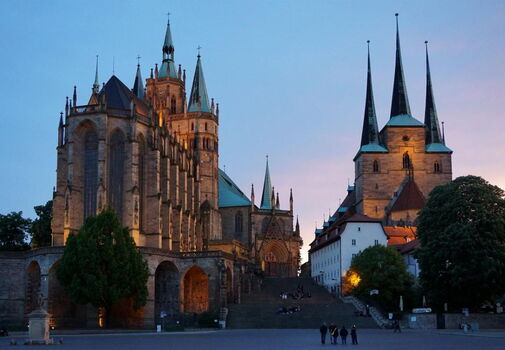 Blick über den Domplatz auf den Dom und daneben liegende St. Severikirche, beleuchtet in der fortgeschrittenen Abenddämmerung