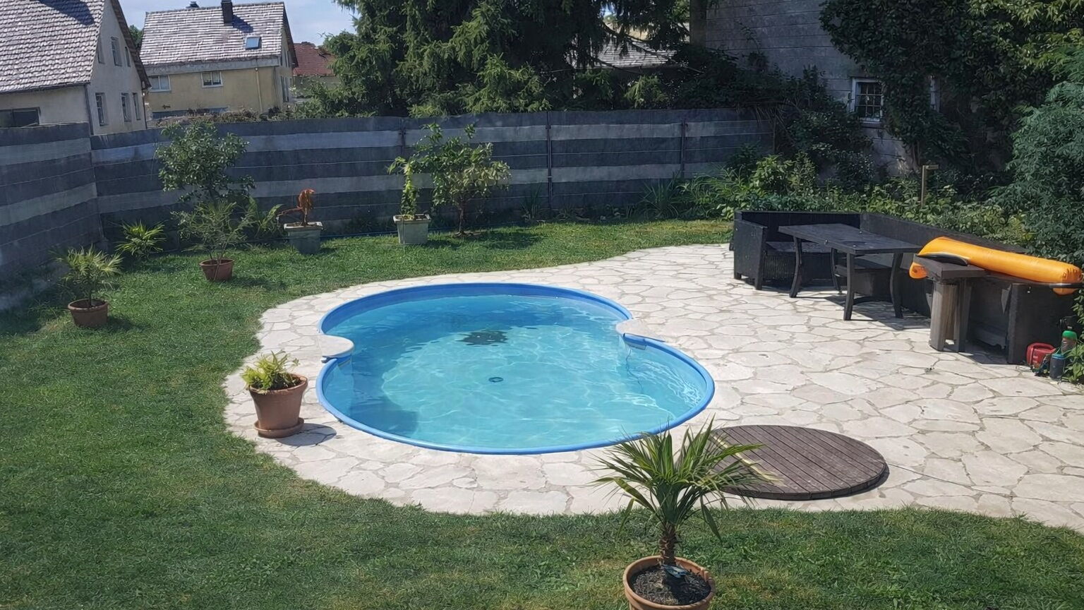 Garten mit Pool und Sitzecke im Sommer