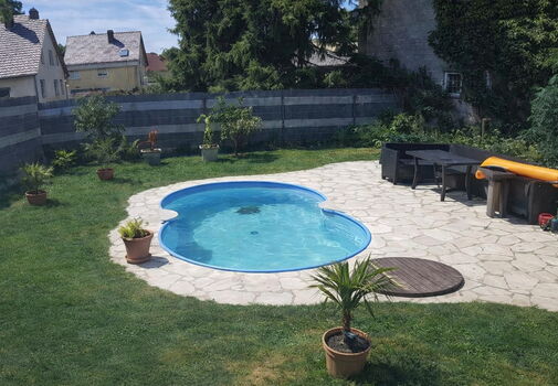 Garten mit Pool und Sitzecke im Sommer